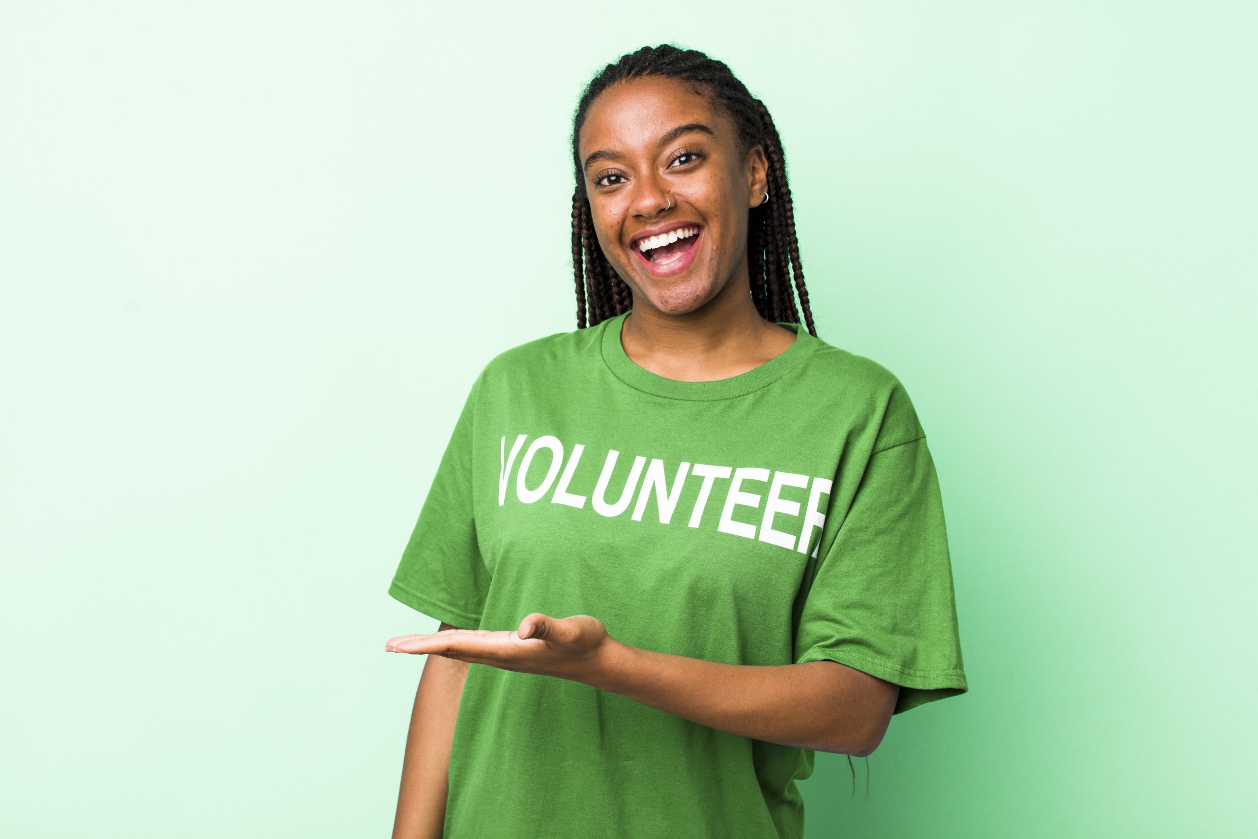 young adult black woman smiling cheerfully, feeling happy and showing a concept